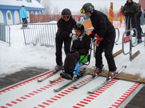People help a boy to ski
