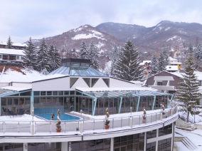 Mountain hotel with swimming pool and mountains in the background