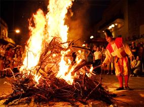 Bonfire with person in traditional dress on the right