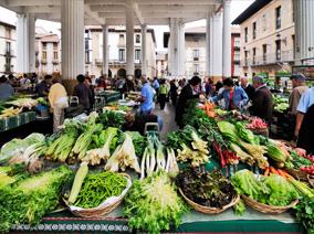 Spanish market with vegetables and many people in the background 