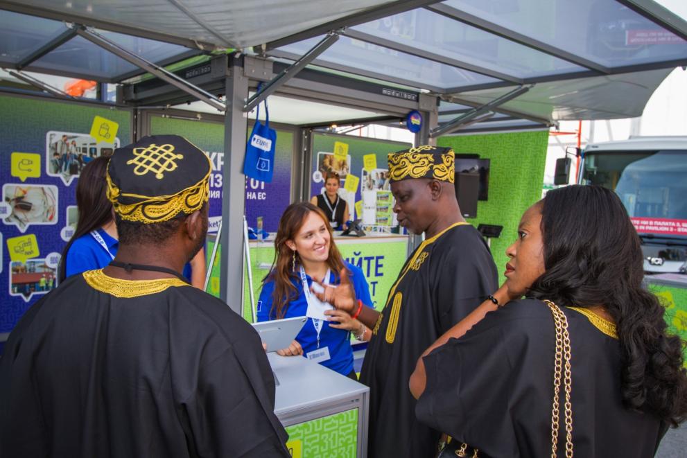 People in traditional African clothes visiting the Tour booth