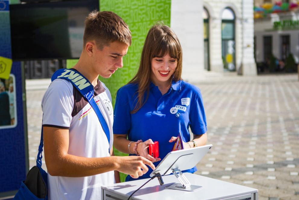 Young man with the Tour hostess playing quiz on a tablet