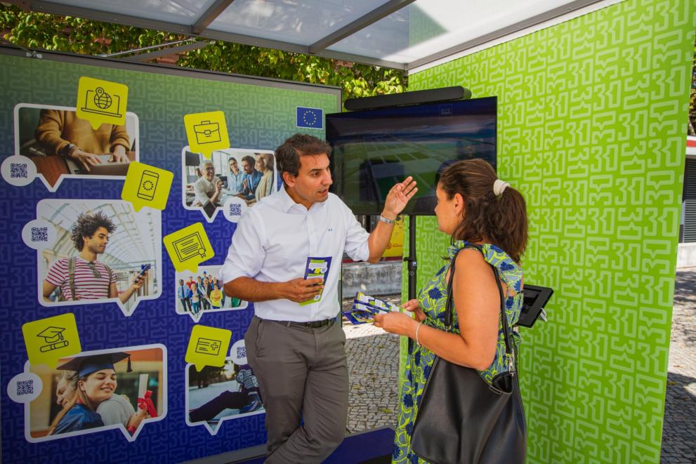 A man talking to a woman at the Tour booth