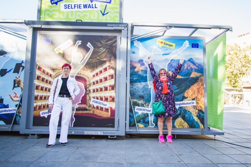 People posing in front of the picture wall