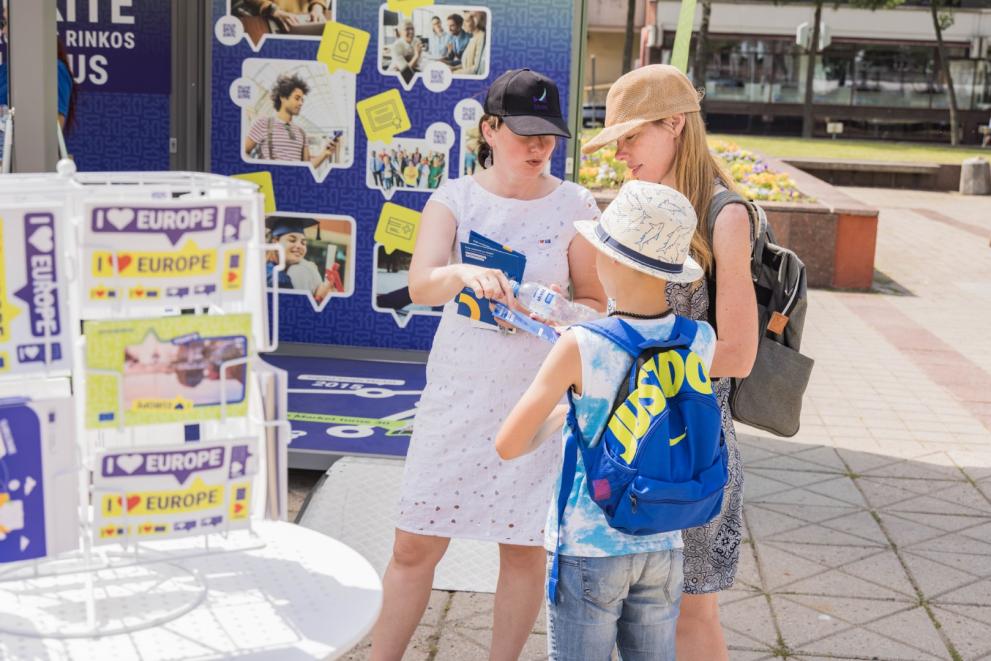 Young people with promotional materials at the Tour stand