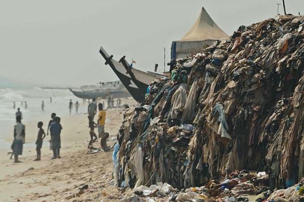 Video still of piles of textile waste on beach in Ghana